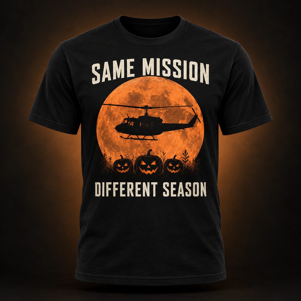 Same Mission, Different Season tee by BySable: a black t-shirt printed with an orange harvest moon, a helicopter silhouette, and jack-o-lanterns above the words Same Mission / Different Season.